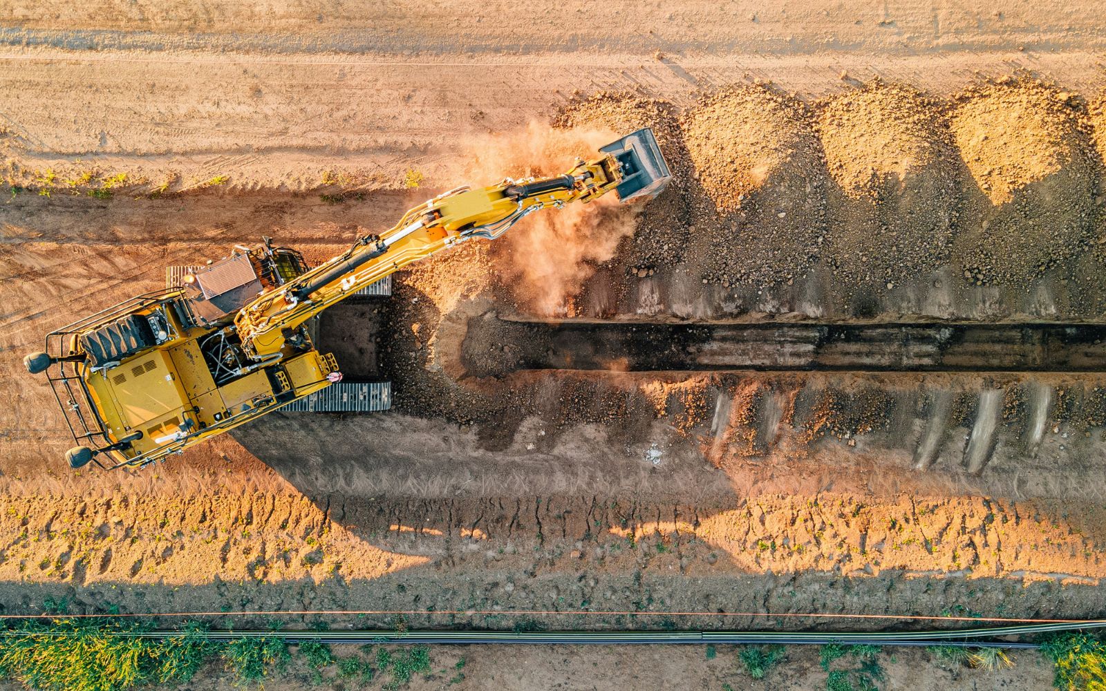 Excavator digging a trench on a work-site.